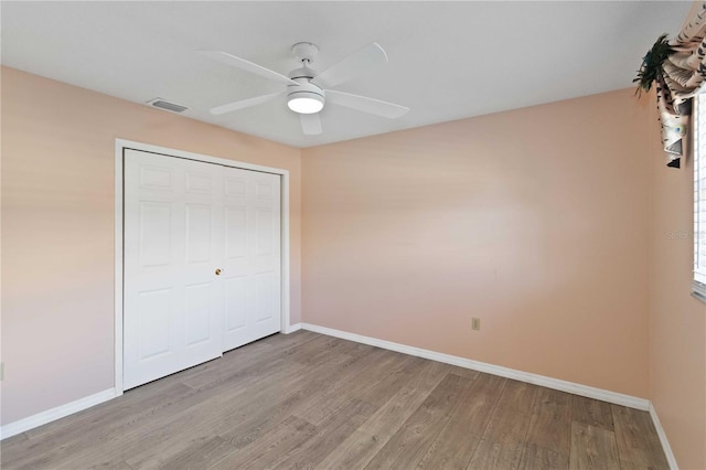 unfurnished bedroom featuring light wood finished floors, baseboards, visible vents, and ceiling fan