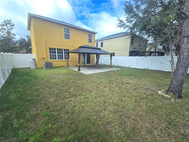 rear view of house featuring a gazebo, a lawn, a patio area, and a fenced backyard