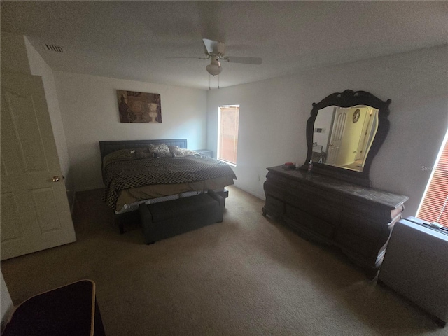 carpeted bedroom with visible vents and ceiling fan