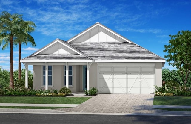 view of front of property featuring a garage, board and batten siding, decorative driveway, and stucco siding