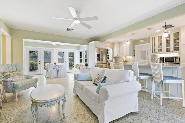 living area featuring light speckled floor, french doors, ornamental molding, and visible vents