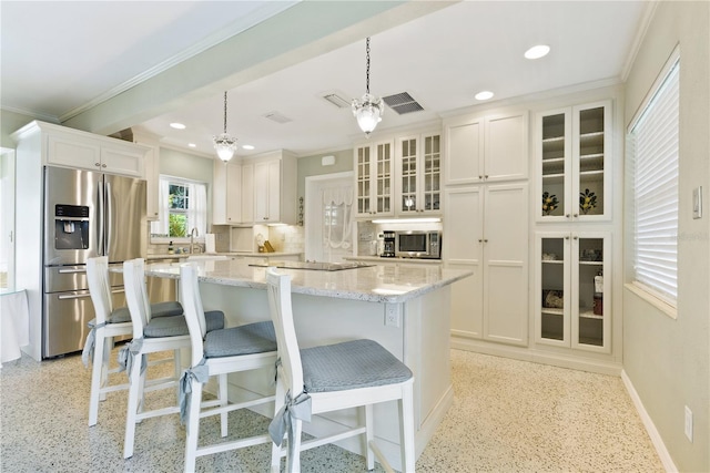 kitchen with white cabinets, light stone countertops, stainless steel appliances, light speckled floor, and a sink