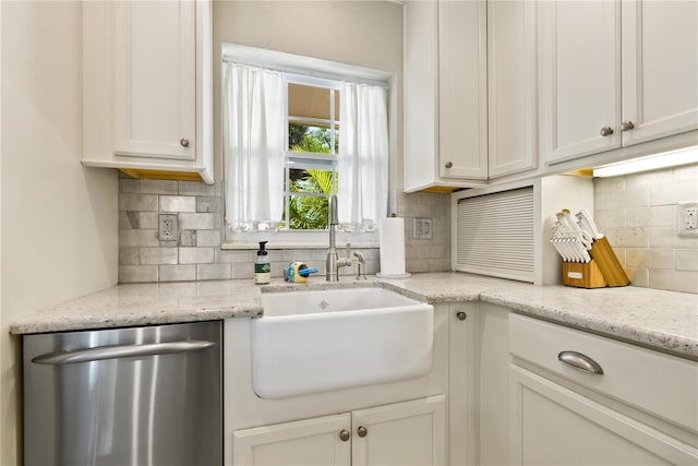 kitchen featuring white cabinets, dishwasher, backsplash, and a sink