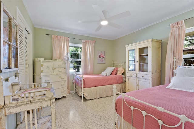 bedroom featuring ornamental molding, speckled floor, a closet, and a ceiling fan