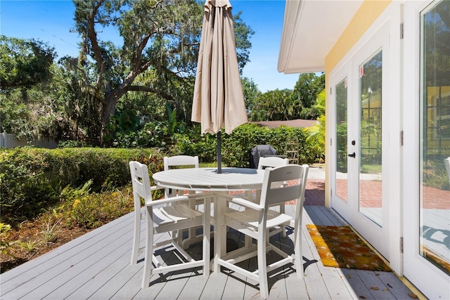 wooden terrace featuring outdoor dining space and french doors