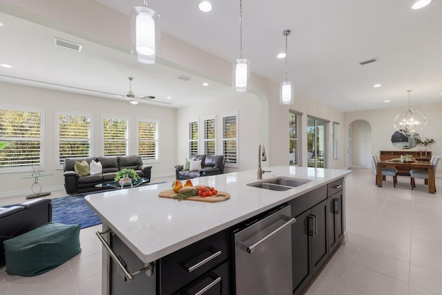 kitchen with arched walkways, open floor plan, dishwasher, and a sink