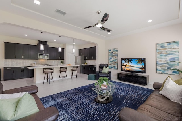 living room featuring arched walkways, ceiling fan, light tile patterned floors, recessed lighting, and visible vents