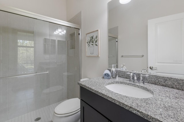 bathroom featuring vanity, toilet, and a shower stall