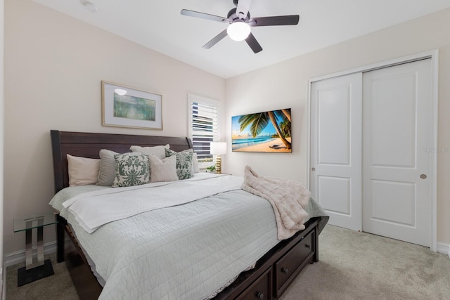 bedroom with a closet, light carpet, ceiling fan, and baseboards