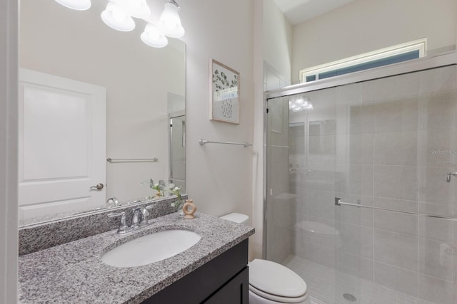 full bathroom with vanity, a shower stall, and toilet