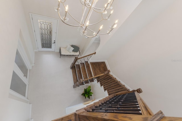 stairs featuring a chandelier and baseboards