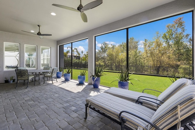 unfurnished sunroom with ceiling fan