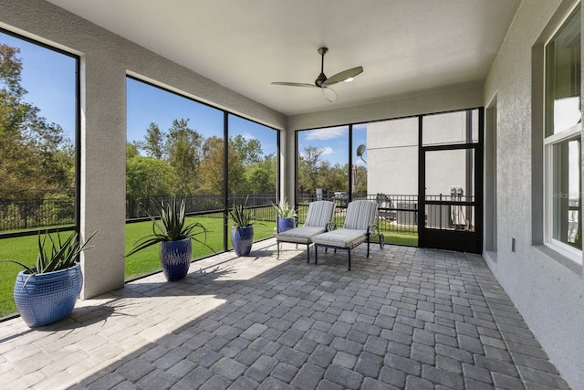 unfurnished sunroom with a ceiling fan