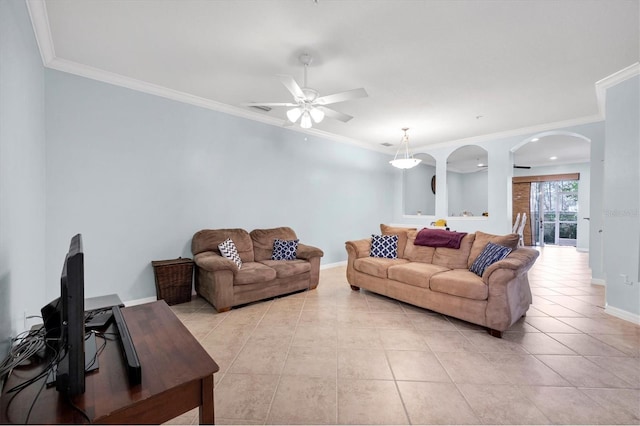 living room featuring light tile patterned floors, baseboards, arched walkways, a ceiling fan, and ornamental molding