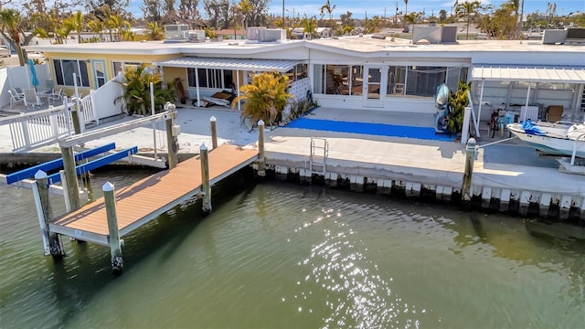 back of house with a patio area, a water view, and boat lift