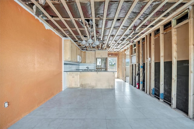 basement featuring light tile patterned flooring, a sink, and refrigerator