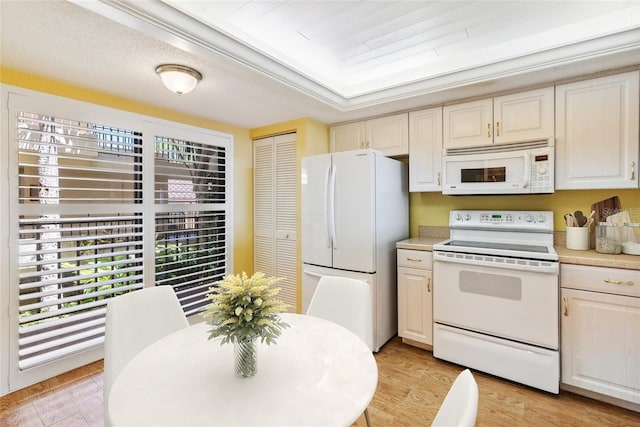 kitchen featuring light wood-type flooring, white appliances, and light countertops