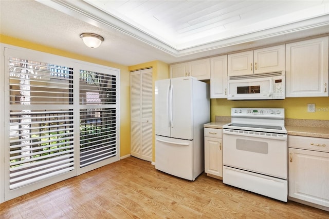 kitchen with white appliances, light countertops, and light wood finished floors