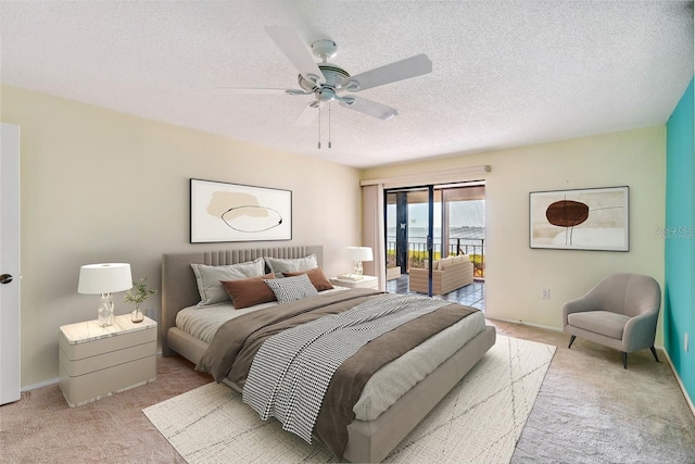 bedroom featuring access to outside, light colored carpet, ceiling fan, and a textured ceiling