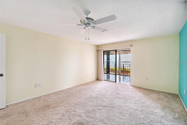 unfurnished room with light carpet, ceiling fan, a textured ceiling, and baseboards