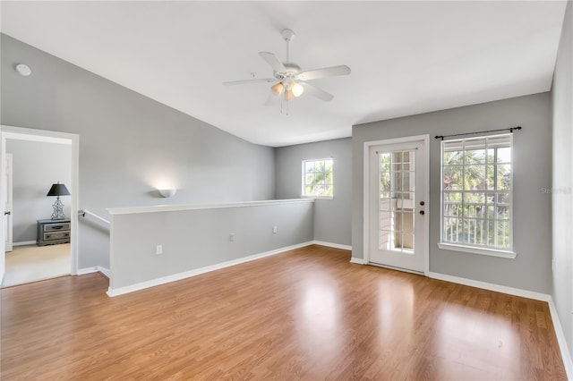 unfurnished room with a ceiling fan, baseboards, and wood finished floors