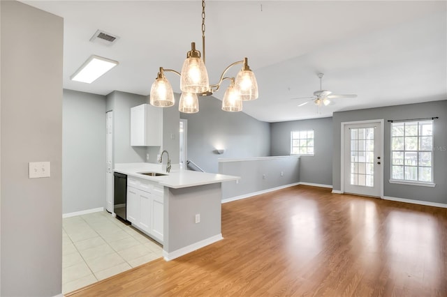 kitchen with a peninsula, a sink, visible vents, white cabinetry, and dishwasher