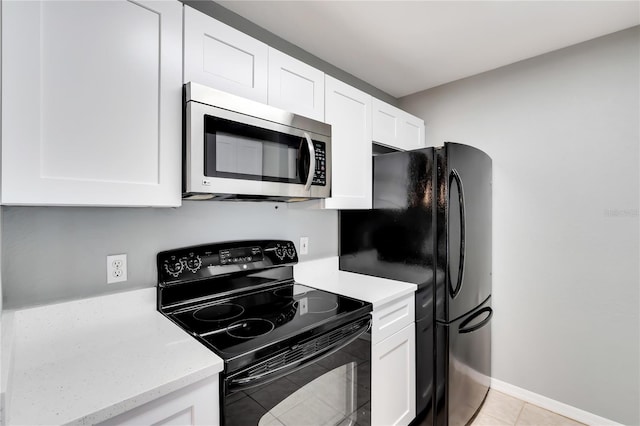 kitchen featuring black appliances, light tile patterned flooring, and white cabinets