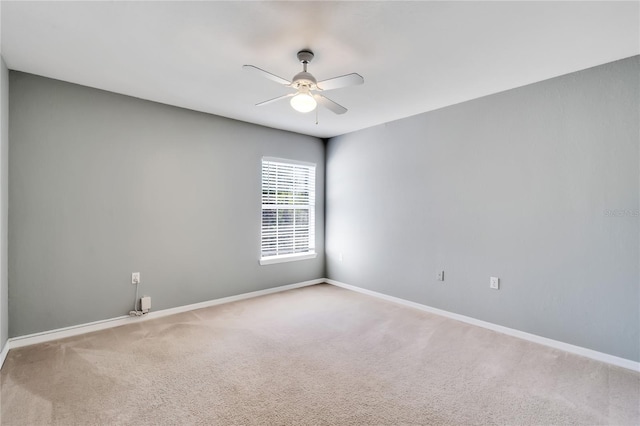 spare room with carpet floors, ceiling fan, and baseboards