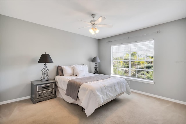 bedroom featuring ceiling fan, baseboards, and light colored carpet