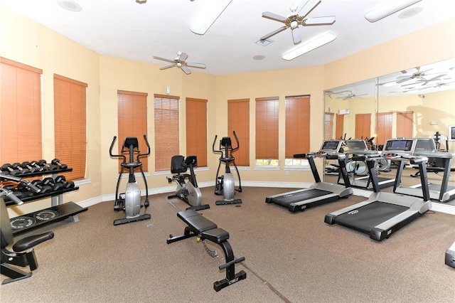 exercise room with ceiling fan and baseboards