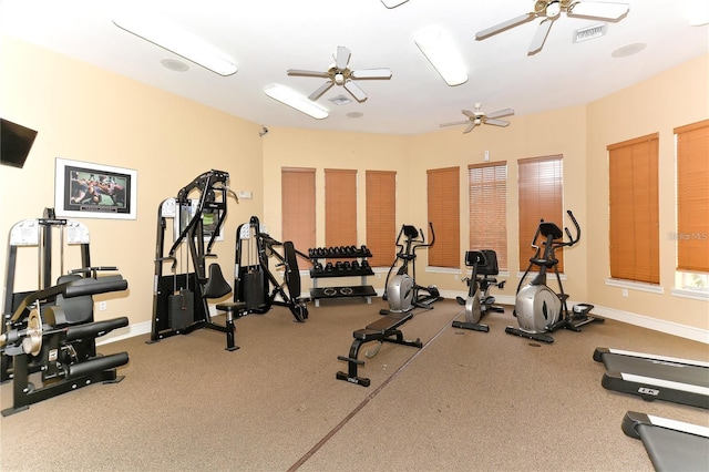 exercise room with a ceiling fan, visible vents, and baseboards