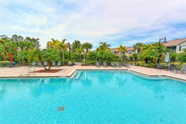 pool with a patio area and fence