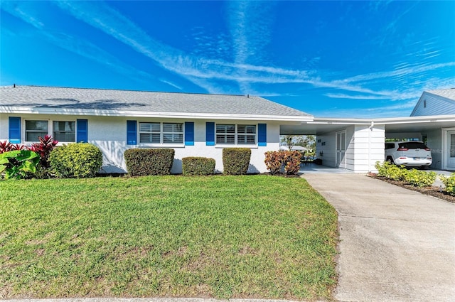 ranch-style home with an attached carport, driveway, a front lawn, and stucco siding