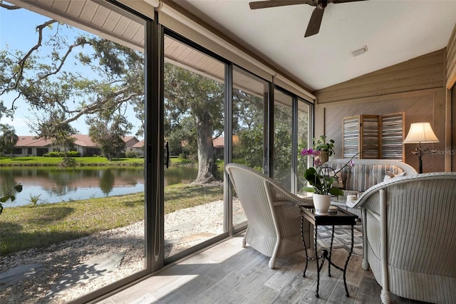 sunroom featuring vaulted ceiling, a water view, visible vents, and a ceiling fan