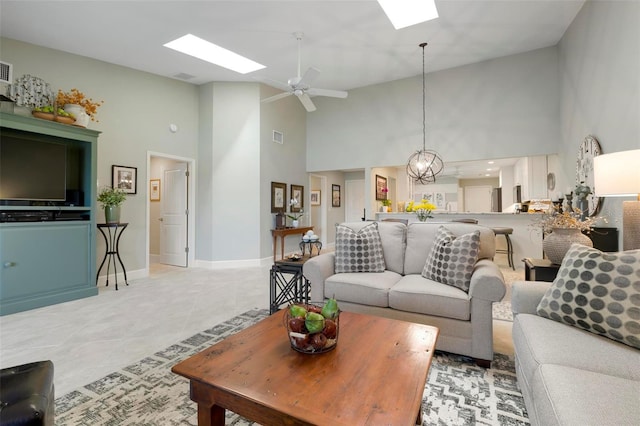 living room with a skylight, ceiling fan, light tile patterned floors, and visible vents