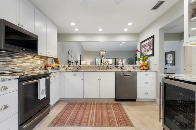 kitchen featuring stainless steel appliances, visible vents, white cabinets, light stone countertops, and beverage cooler