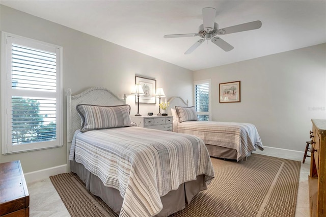 bedroom with ceiling fan and baseboards