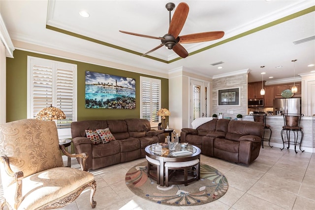 living room featuring light tile patterned flooring, visible vents, and crown molding