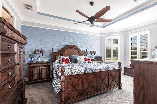 bedroom with ceiling fan, visible vents, ornamental molding, carpet, and a raised ceiling