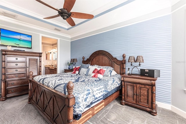 carpeted bedroom featuring baseboards, visible vents, a tray ceiling, and crown molding