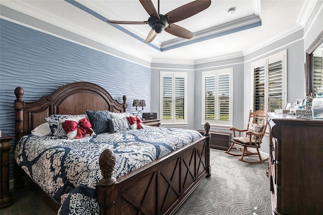 carpeted bedroom featuring a ceiling fan, a tray ceiling, and crown molding