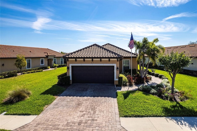 view of front of house featuring a garage, a tile roof, decorative driveway, a front lawn, and stucco siding