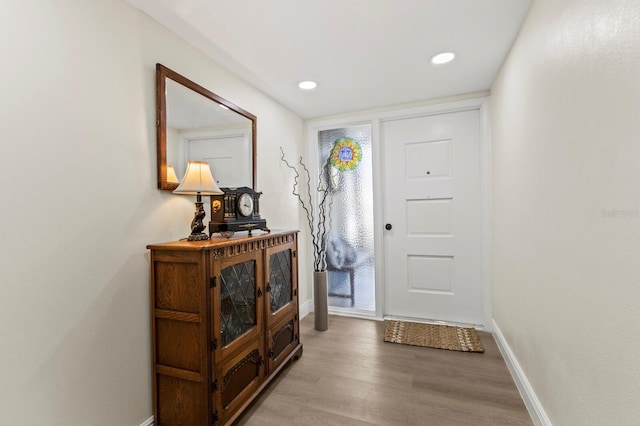 foyer entrance with light wood-style floors, recessed lighting, and baseboards