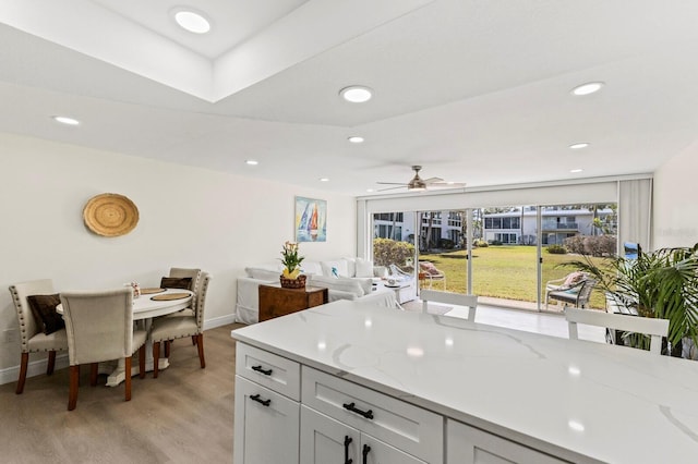 kitchen featuring light stone counters, recessed lighting, light wood-style flooring, white cabinets, and baseboards