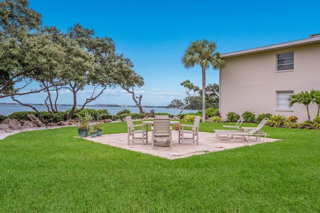 view of yard with a water view and a patio