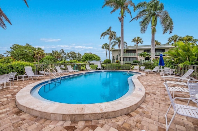 community pool featuring a patio and fence