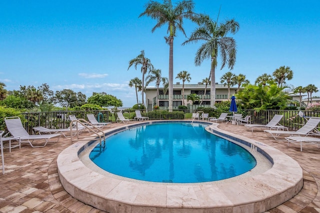 community pool featuring a patio area and fence