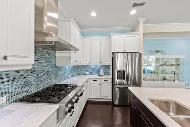 kitchen with visible vents, dark wood finished floors, appliances with stainless steel finishes, wall chimney range hood, and backsplash