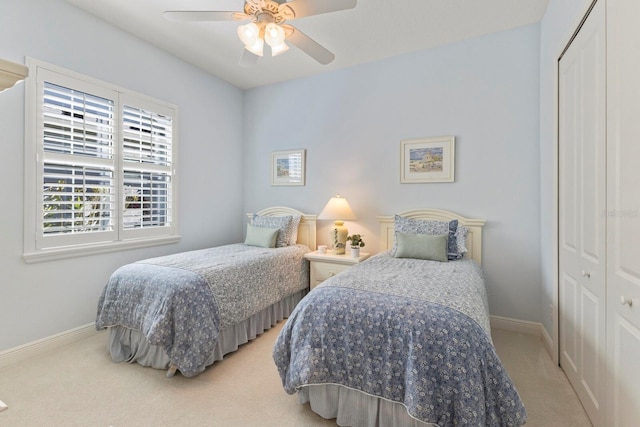 carpeted bedroom featuring a closet, ceiling fan, and baseboards