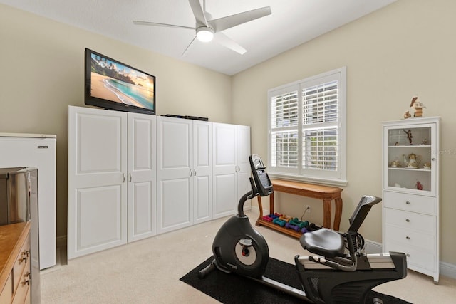 workout room with a ceiling fan, light carpet, and baseboards